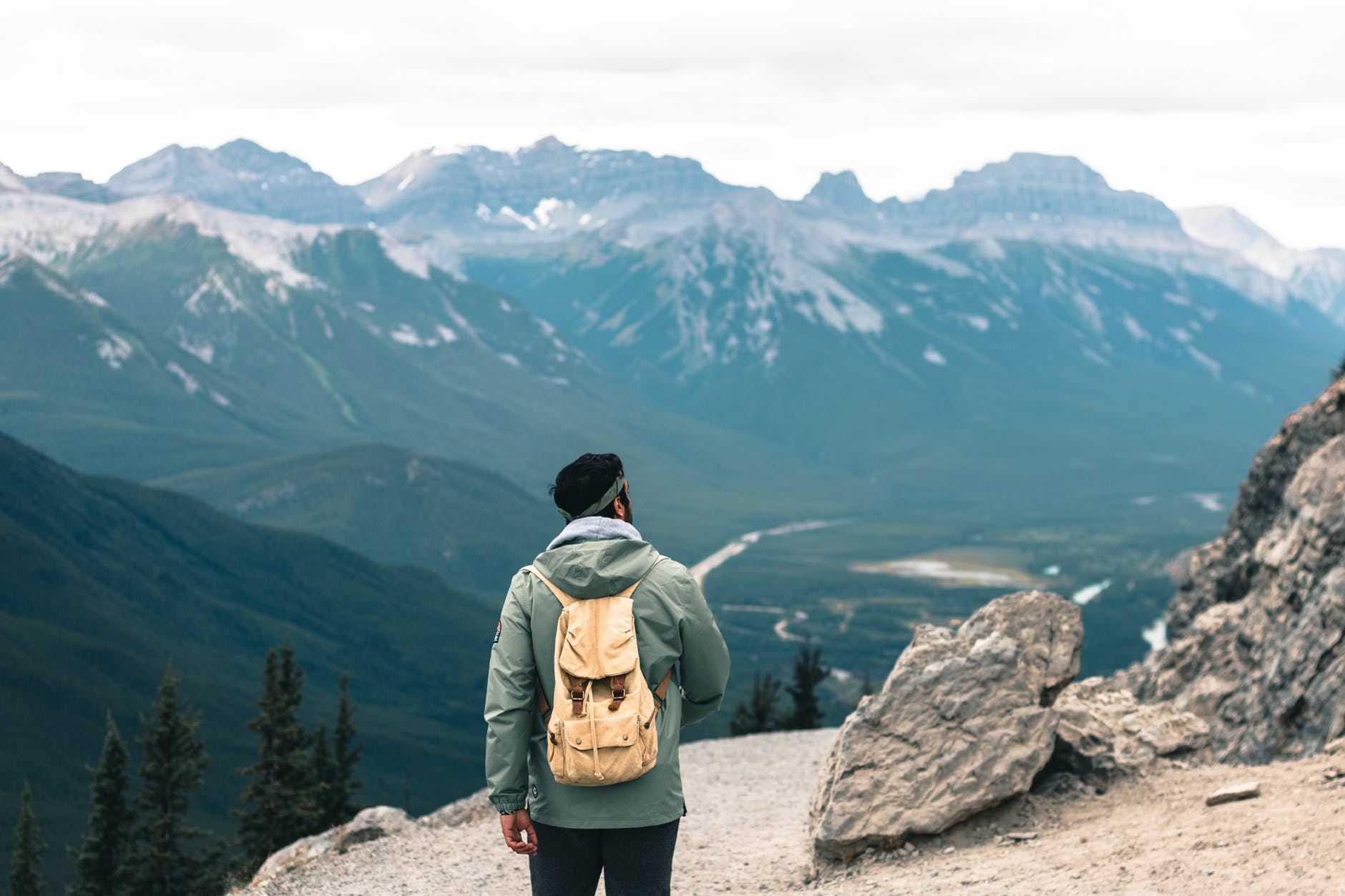 a man in hoodie jacket standing near big rocks